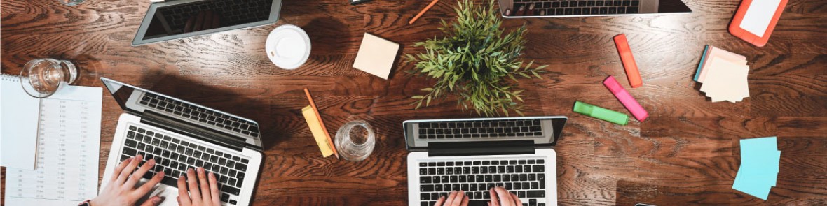 desktop with a laptop and people working